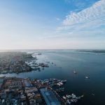 Vista aérea do porto de Manaus, com embarcações no Rio Negro e a paisagem urbana ao fundo